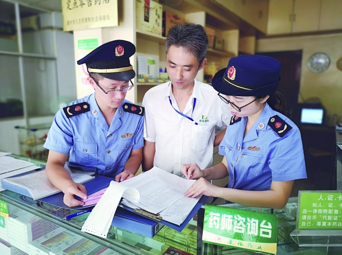 執(zhí)法人員在一家藥店檢查特殊藥品進貨臺賬。