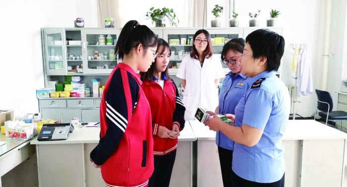 圖為執(zhí)法人員向?qū)W生普及安全用藥知識。