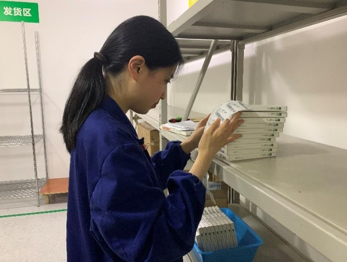 圖為金華市中心醫(yī)院工作人員將追溯二維碼粘貼到醫(yī)療器械包裝盒上。何璇 攝