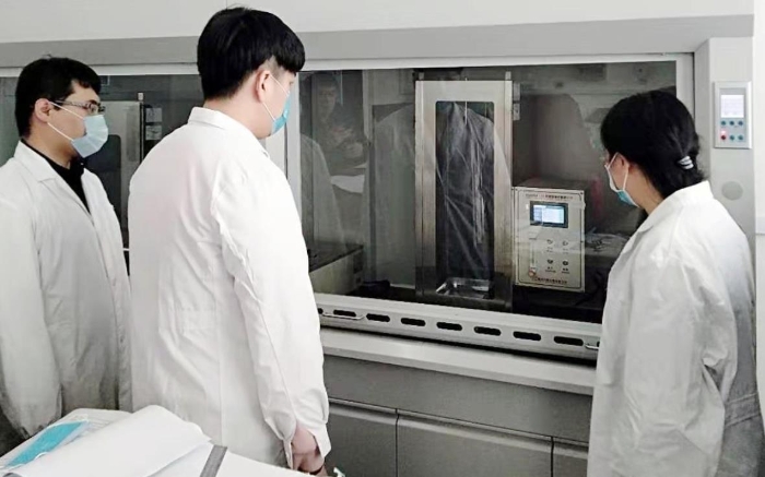 圖為吉林器械所檢驗(yàn)人員開展疫情防護(hù)用品的阻燃試驗(yàn)。