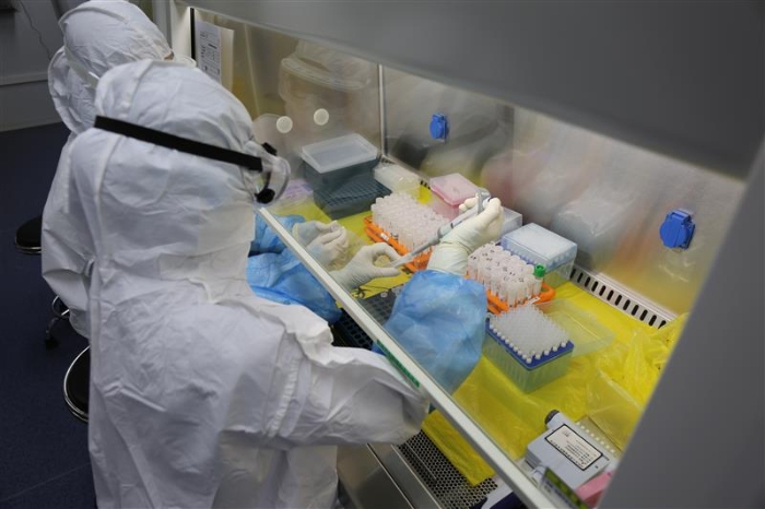 “火眼”自動(dòng)化提取室內(nèi)，檢測(cè)人員在進(jìn)行自動(dòng)化核酸提取的樣本準(zhǔn)備。