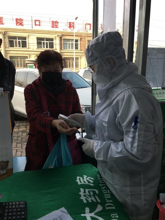 趙海霞為進(jìn)店顧客測量體溫。