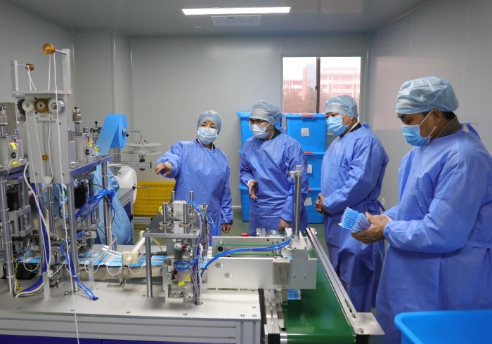 監(jiān)管人員現(xiàn)場檢查指導企業(yè)開展醫(yī)用口罩生產。程奇攝