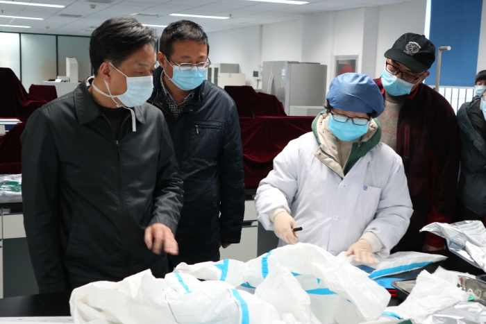 圖為湖北省藥監(jiān)局鄧小川（左一）帶領(lǐng)武漢分局執(zhí)法人員對(duì)防護(hù)用品生產(chǎn)企業(yè)進(jìn)行現(xiàn)場(chǎng)檢查。（湖北省藥監(jiān)局武漢分局供圖）