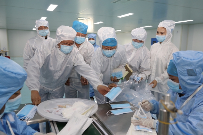 “五_一”小長假期間，新疆維吾爾自治區(qū)藥監(jiān)局黨組書記、局長張鈺祥（左一）帶隊(duì)赴哈密市調(diào)研口罩生產(chǎn)企業(yè)。（馬少賓 攝）