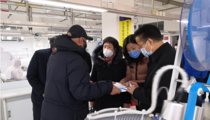 李璐（右二）督導期間聽取煙臺舒朗公司負責人醫(yī)用防護服改進設計的介紹。