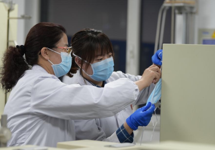 技術(shù)人員對(duì)口罩等疫情防控用品進(jìn)行檢驗(yàn)。