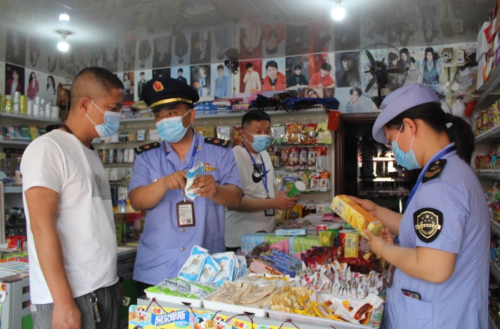 執(zhí)法人員在一學(xué)校周邊的食雜店進(jìn)行執(zhí)法檢查