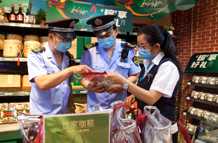 東城區(qū)市場(chǎng)監(jiān)管局執(zhí)法人員在超市檢查粽子保質(zhì)期。