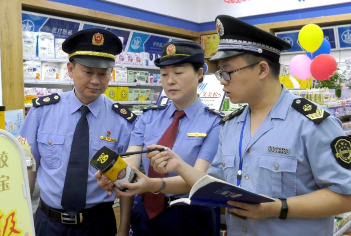 圖為該局執(zhí)法人員在一家藥店檢查藥品保質(zhì)期。
