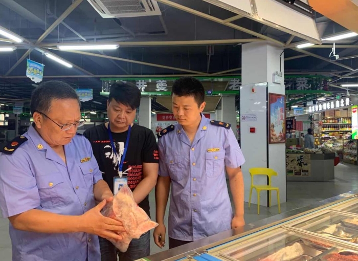 圖為該局執(zhí)法人員在一家農(nóng)貿(mào)市場(chǎng)冷凍食品專柜進(jìn)行檢查。