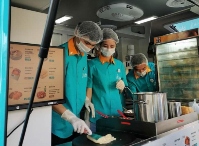 “逸小兔”流動早餐車的店員正在為顧客備餐。新華網(wǎng)發(fā)（熊多多 攝）