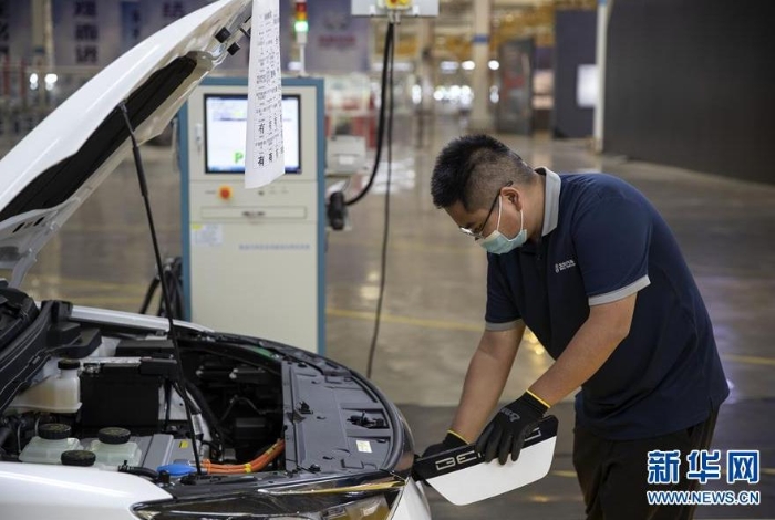 一名工作人員在北汽昆明基地檢查新能源汽車充電口（8月18日攝）。新華社記者 孫敏 攝