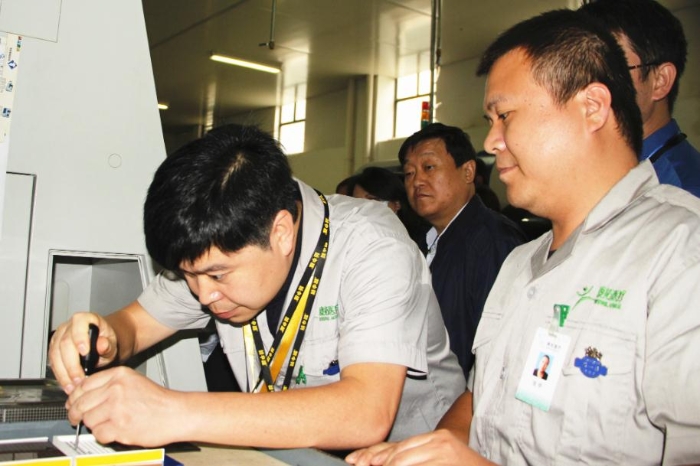 工作人員在生產車間現(xiàn)場向大家演示產品和工具的精準配合性能（賀一辰 攝）