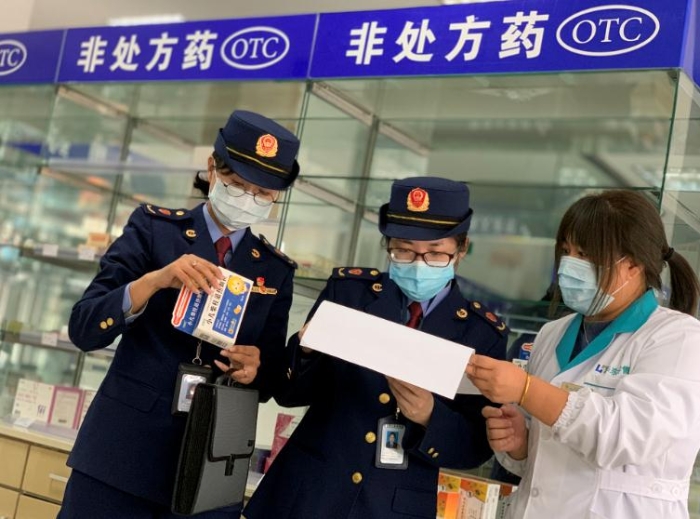 圖為該局執(zhí)法人員對發(fā)燒類藥品銷售登記進行檢查。