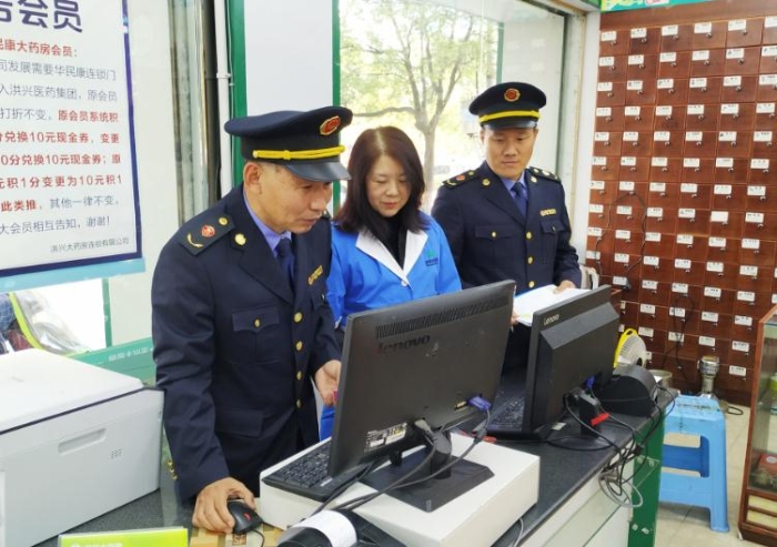 圖為執(zhí)法人員在查看藥店處方藥銷售臺賬。