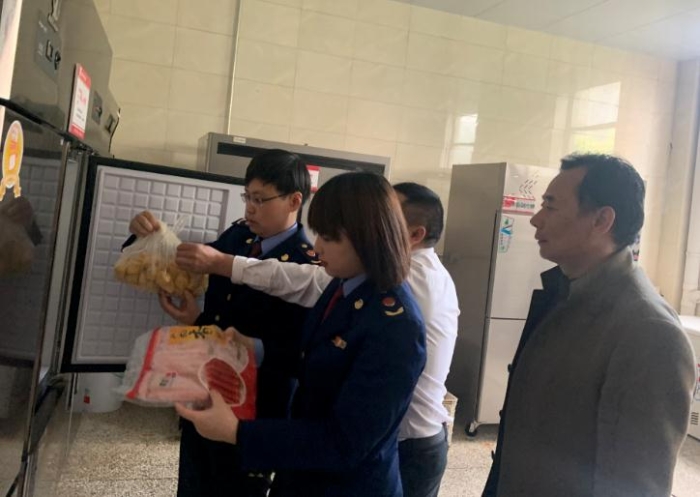 圖為該局執(zhí)法人員檢查學(xué)校食堂食品原料。
