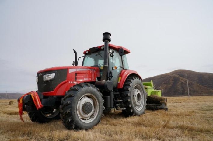 在青海省果洛藏族自治州甘德縣江千鄉(xiāng)，一位牧民正在飼草基地駕駛打捆機(jī)工作。（2020年11月3日攝）。新華社記者陳凱 攝
