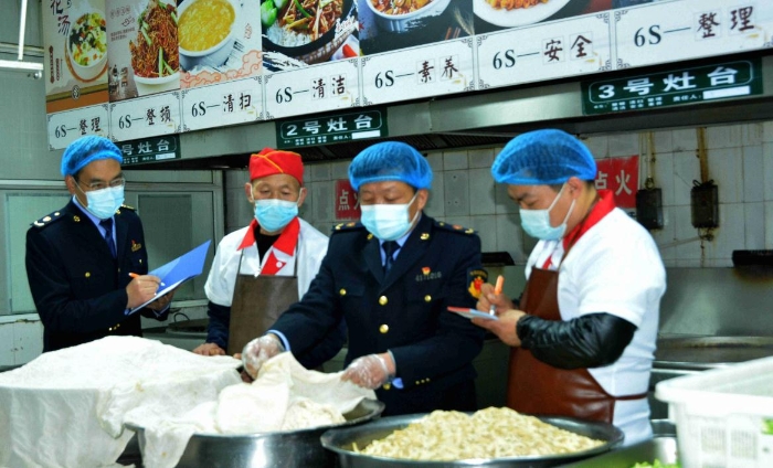 圖為4月7日，執(zhí)法人員在檢查某學(xué)校食堂操作間衛(wèi)生。