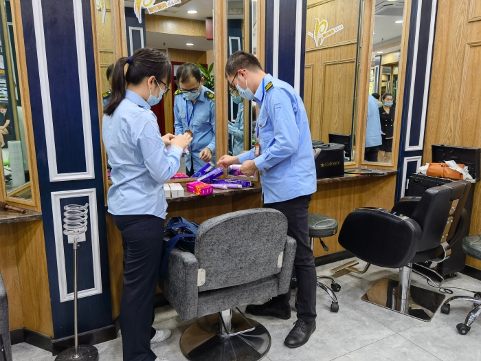 執(zhí)法人員對青秀區(qū)美容美發(fā)機構(gòu)的染發(fā)產(chǎn)品進行監(jiān)督抽檢。