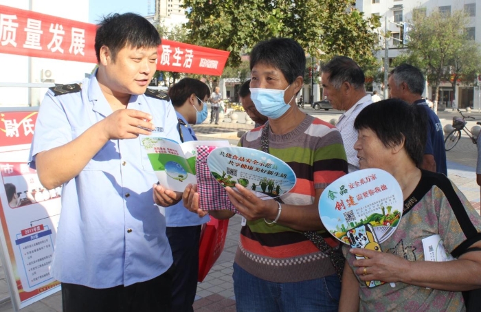 圖為執(zhí)法人員向群眾宣講食品安全知識(shí)。