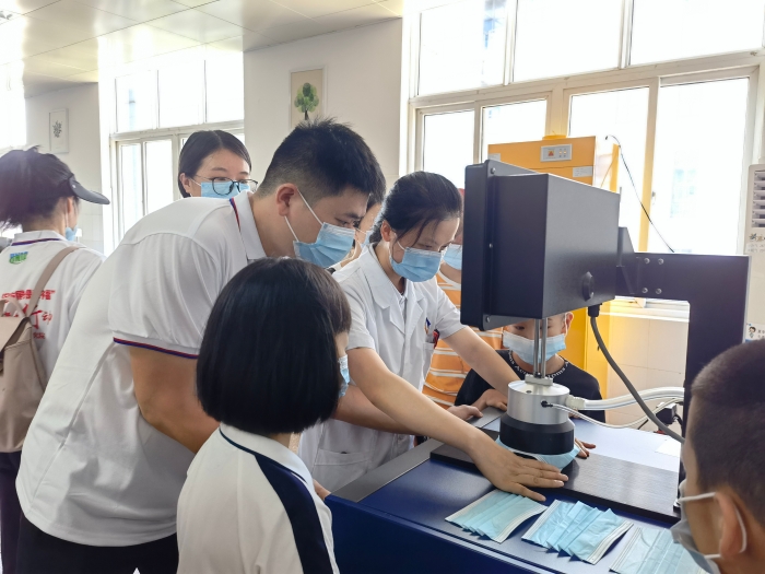 圖為技術(shù)人員在講解口罩的檢驗(yàn)方法和原理。（喻燦華 攝）