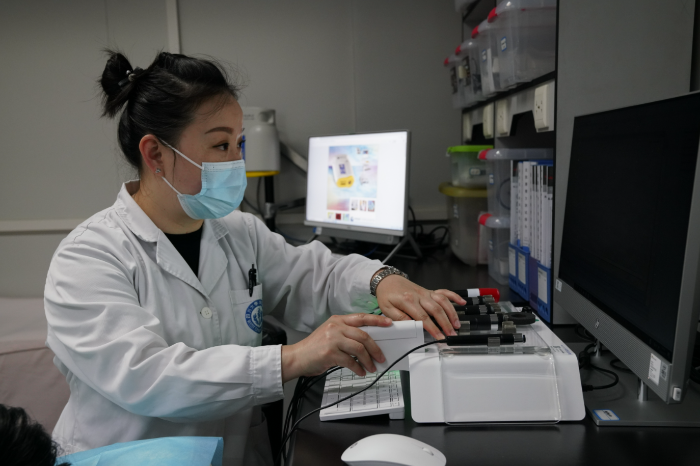 圖為實(shí)驗(yàn)室工作人員在使用無創(chuàng)測(cè)量?jī)x器測(cè)量皮膚生理參數(shù)。實(shí)驗(yàn)室供圖