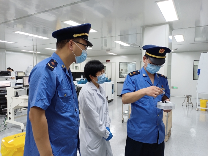 圖為執(zhí)法人員在一家醫(yī)療機構(gòu)檢查新冠病毒檢測試劑使用情況。