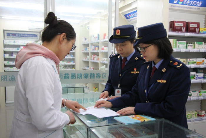 圖為執(zhí)法人員在佰藥之家大藥房發(fā)放安全用藥科普手冊(cè)。