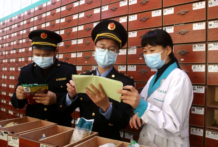 圖為11月24日執(zhí)法人員對一家藥店檢查中藥飲片。