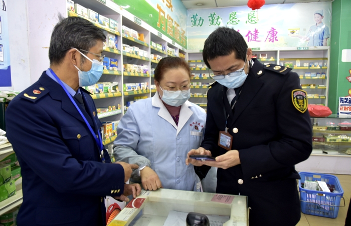 圖為執(zhí)法人員在一家藥店檢查藥品經(jīng)營(yíng)者的智慧監(jiān)管系統(tǒng)的使用情況。