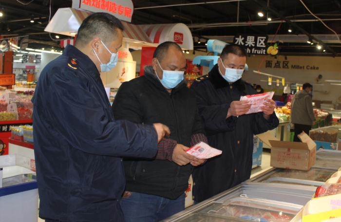 圖為執(zhí)法人員在一商場(chǎng)檢查冷凍湯圓標(biāo)簽標(biāo)識(shí)