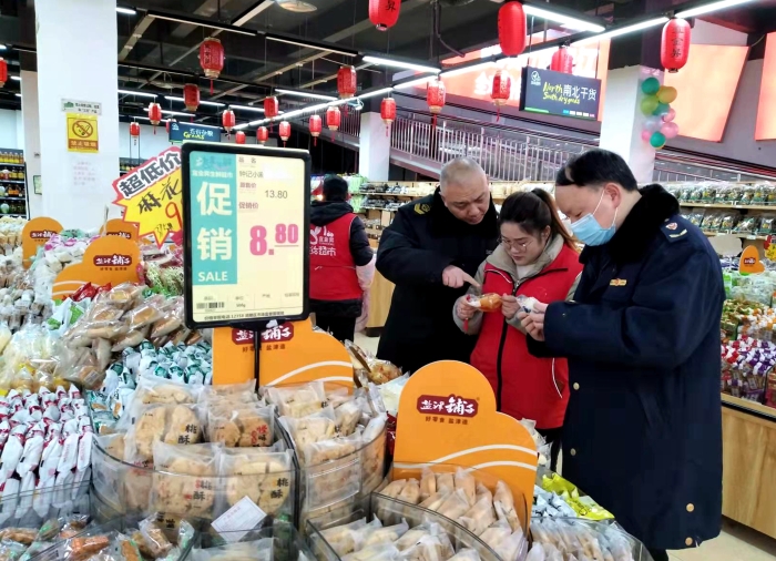 圖為執(zhí)法人員在檢查散裝餅干的生產(chǎn)日期。（王玲玲 攝）