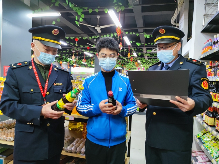圖為執(zhí)法人員在一家超市檢查調(diào)味品質(zhì)量。
