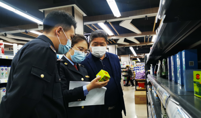 圖為執(zhí)法人員在化妝品銷售現(xiàn)場進行檢查。