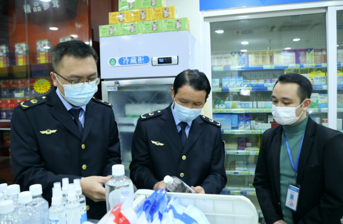 圖為執(zhí)法人員檢查口罩、酒精等防疫物資。