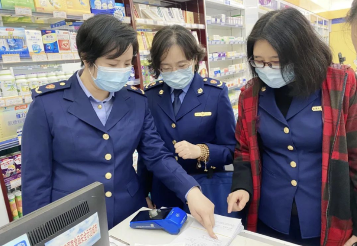 圖為執(zhí)法人員檢查藥品銷售記錄。