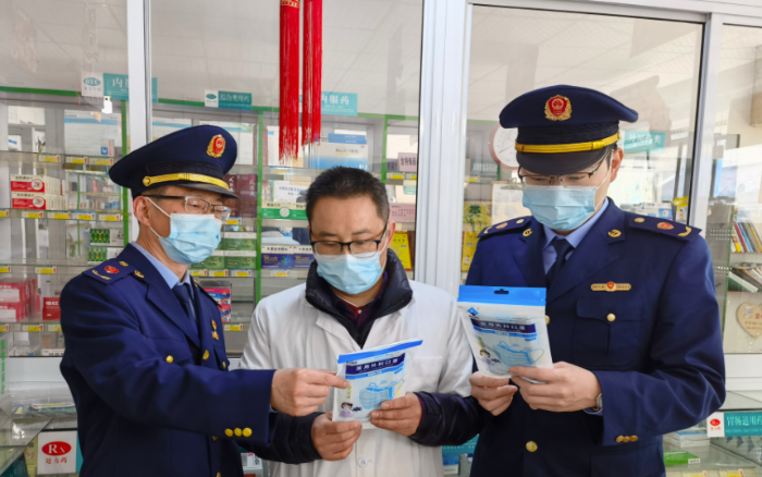 圖為執(zhí)法人員檢查藥店防疫物資。