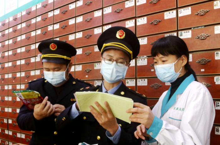 圖為執(zhí)法人員檢查中藥飲片。