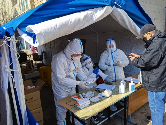 圖為吉林省藥監(jiān)局黨員干部在社區(qū)發(fā)放新冠抗原檢測(cè)試劑盒