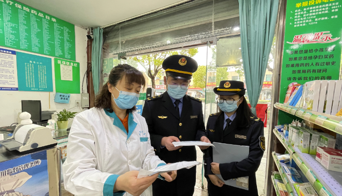 圖為執(zhí)法人員在一家藥店檢查疫情防控情況。