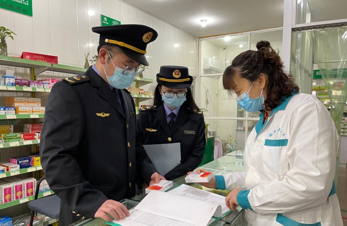 圖為執(zhí)法人員正在一家藥店檢查藥品信息登記情況。