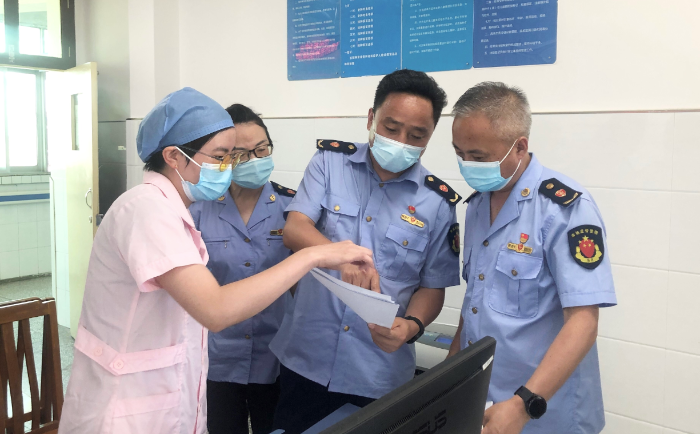 圖為城固縣市場監(jiān)管局執(zhí)法人員查驗疫苗、檢測試劑相關資質和冷鏈記錄。