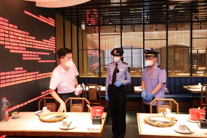 圖為海淀區(qū)市場監(jiān)管局執(zhí)法人員在現(xiàn)場檢查疫情防控及食品安全情況。