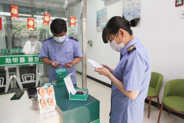 圖為執(zhí)法人員檢查助聽器經(jīng)營企業(yè)產(chǎn)品質(zhì)量安全。