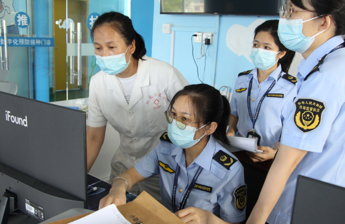 圖為鐘山縣市場(chǎng)監(jiān)管局執(zhí)法人員在一家疫苗接種單位檢查相關(guān)資質(zhì)文件。