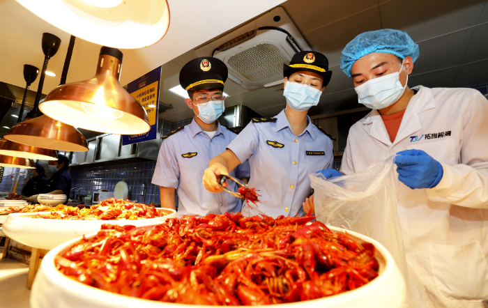 圖為8月2日，淮北市市場監(jiān)督管理部門工作人員在夜市餐飲街區(qū)現(xiàn)場取樣。