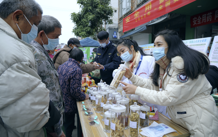 圖為工作人員現(xiàn)場向群眾講解常用中藥材的鑒別知識(shí)，普及藥品安全相關(guān)法律法規(guī)。
