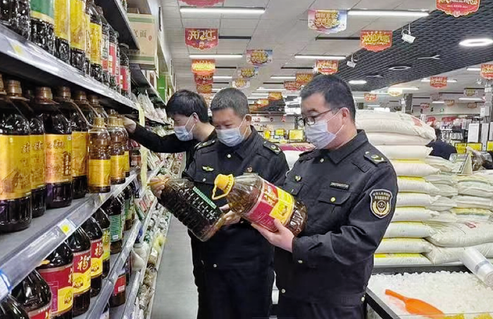 圖為該局執(zhí)法人員在一家超市檢查食用植物油包裝標簽標識。