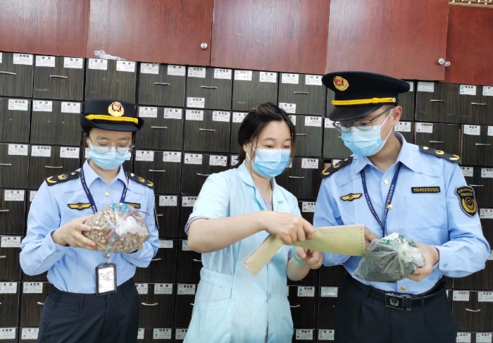 圖為執(zhí)法人員對中藥飲片進行現(xiàn)場檢查。